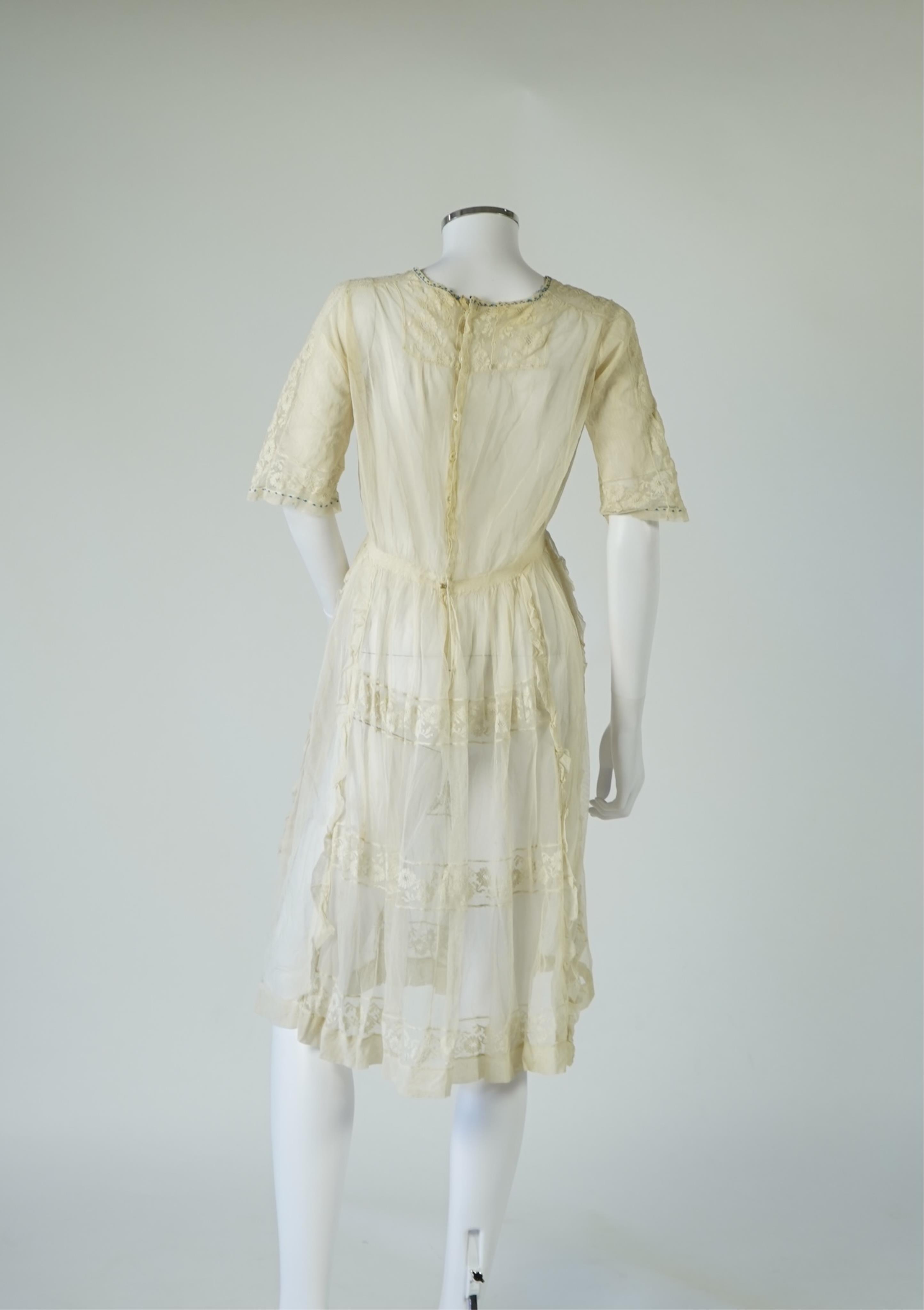 An early 20’s cream net ladies summer dress and net petticoat, designed with a lace inset front skirt, yolk and sleeves.103cm long. Condition - both need re-laundering and some seams tidying.